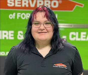 White female smiling in front of SERVPRO truck