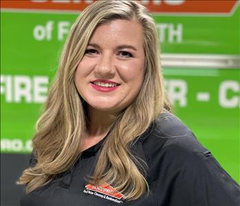 White female smiling in front of SERVPRO truck