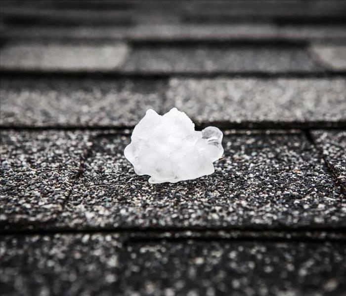 hail ice on a black roof shingle